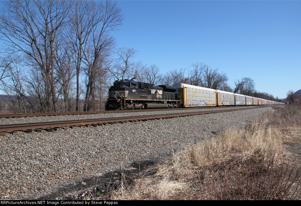 NS 1107 takes a string of autoracks west at MP 116